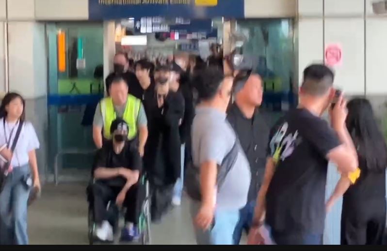 Lee Know(左)坐輪椅現身,因為先前在MAMA表演途中「腳踝受傷」。(圖/記者黃啟超攝影)